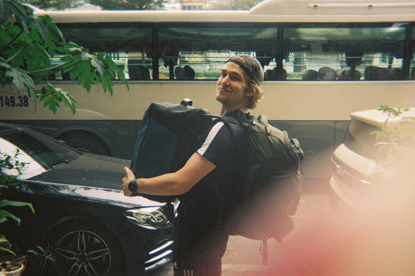 Jonty carrying two backpacks in Vietnam, shot on film
